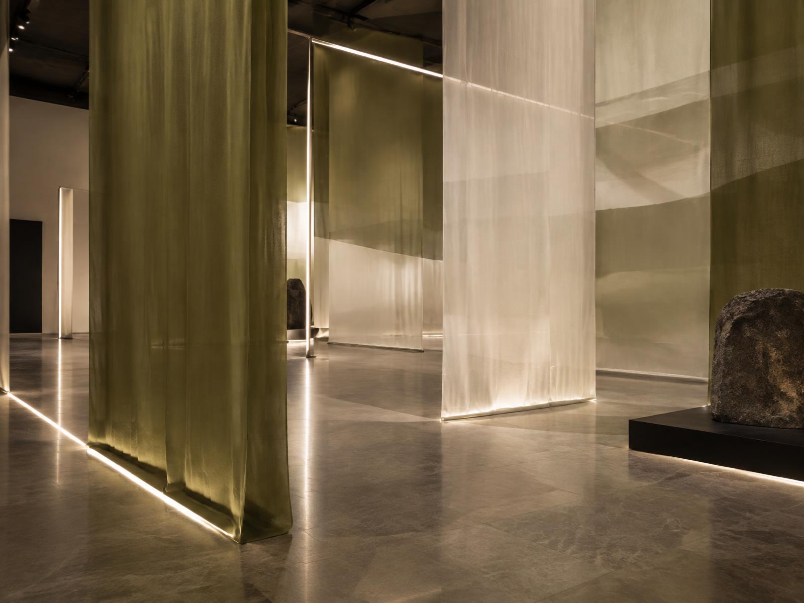 Immersive installation of translucent olive and ivory fabric planes